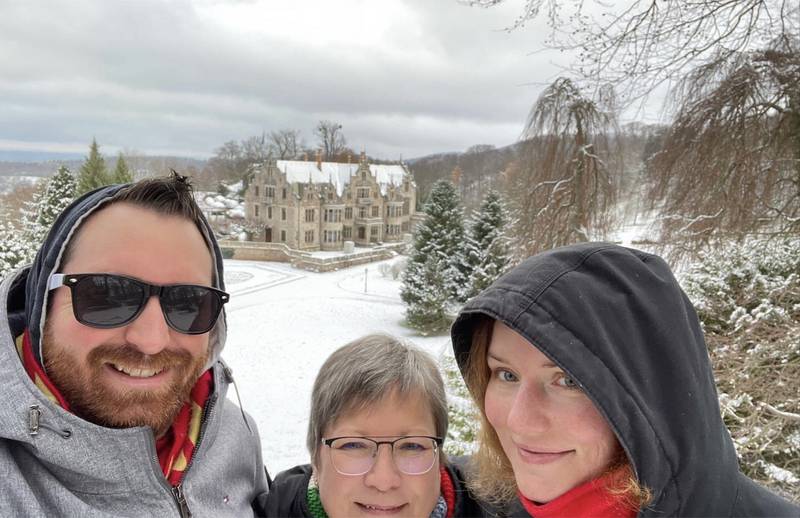 Doug Turnbull (left), wife Momo, and her mom Ulrike Lesser pose in front of a snowy castle in Bad Liebenstein, Germany on December 10, 2022.